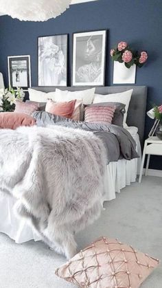 a bedroom with blue walls and white bedding, pink flowers on the nightstands