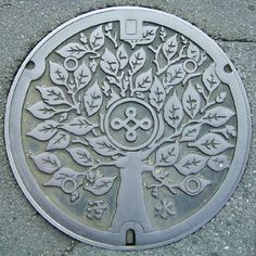 a manhole cover with a tree design on it