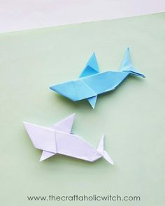 two origami fish are sitting next to each other