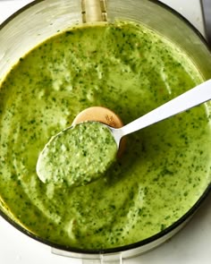 a spoon in a food processor filled with pesto