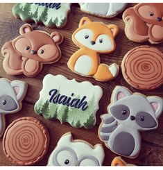 some cookies that are on top of a wooden table with animals and trees in the background