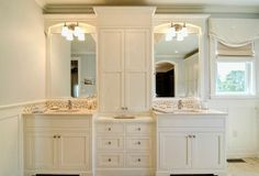 a bathroom with two sinks, mirrors and cabinets in the middle of it is shown