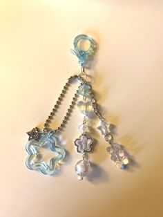 a close up of a key chain on a white surface with beads hanging from it