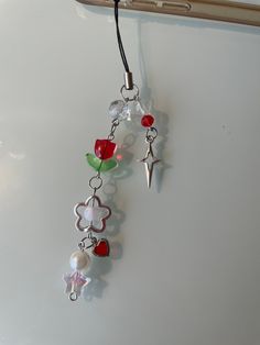 a cell phone hanging from a cord with beads and charms attached to it's side