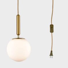 a white ball hanging from a brass colored light fixture with a cord attached to it