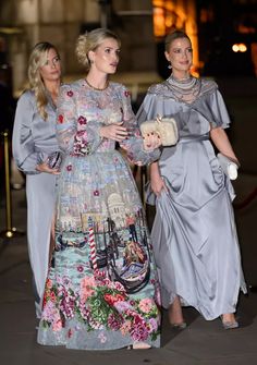 two women walking down the street in dresses with long sleeves and floral print on them