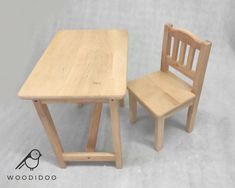 two wooden chairs sitting next to each other near a small table with a chair on it