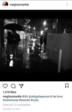 two people standing under an umbrella on a city street at night in black and white