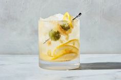 a glass filled with ice and lemons on top of a table next to a wall