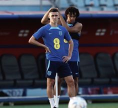 two soccer players standing next to each other on the field