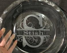 a glass plate with the letter g on it and a hand holding up an object in front of it