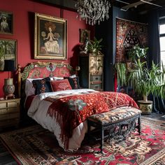 a bedroom decorated in red and black with an ornate bed, chandelier, potted plants, and paintings on the wall