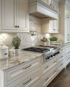 a kitchen with white cabinets and marble counter tops, along with a stove top oven