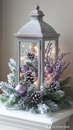 a lantern filled with christmas decorations on top of a mantle