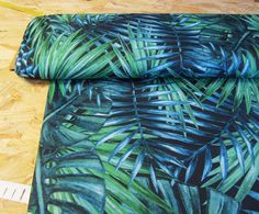 a close up of a green and blue palm leaf print fabric