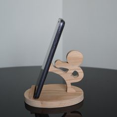 a cell phone is sitting on top of a wooden stand with a pen in it