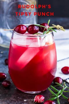 a glass filled with cranberry shrub and garnished with fresh cherries