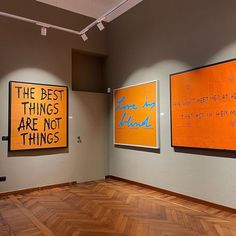 three paintings on the wall in an empty room with wooden floors and hard wood flooring