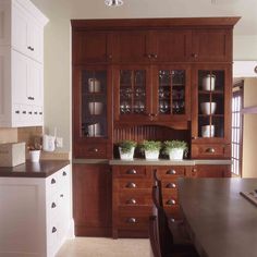 a kitchen with wooden cabinets and white cupboards