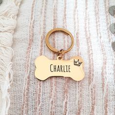 a dog bone shaped keychain with the name charlie engraved on it's front