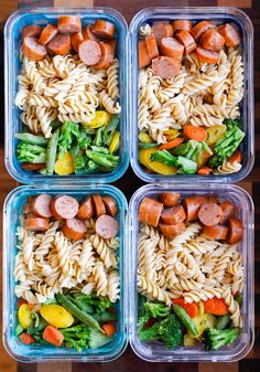 four plastic containers filled with pasta and veggies