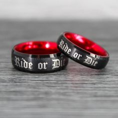 two red and black wedding rings with the words ride or die on each one side