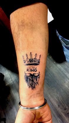 a man with a crown tattoo on his arm