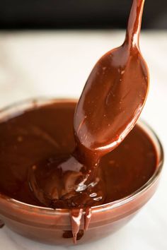 a spoon full of melted chocolate in a bowl