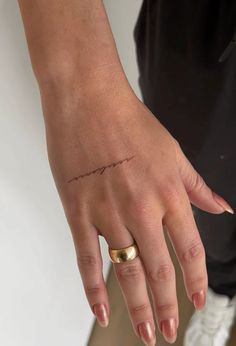 a woman's hand with a small tattoo on it