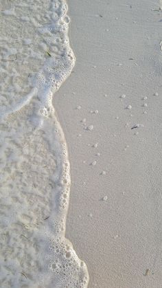 footprints in the sand and water at the beach