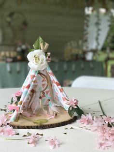 a teepee with flowers on it sitting on top of a table