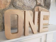 wooden letters spelling out the word one on a mantle