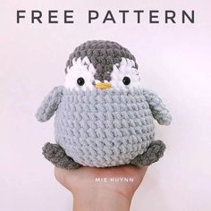 a hand holding a small crocheted penguin with the text free pattern on it