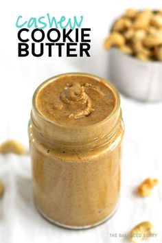 a jar filled with cashew cookie butter sitting on top of a white tablecloth