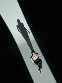 a woman standing in the middle of a long shadow