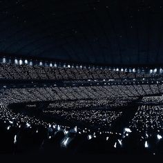 a large group of people are standing in the dark