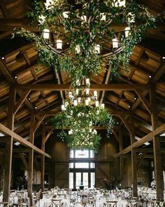 the inside of a large wooden building with tables and chairs set up for an event