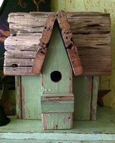 a birdhouse made out of old wood sitting on top of a shelf