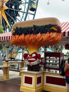 a hot dog on a bun with fire in the middle at an amusement park or fair