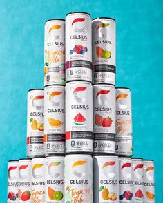 several cans of celsius are stacked on top of each other in front of a blue background