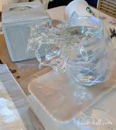 a glass bowl filled with water sitting on top of a white table next to other items