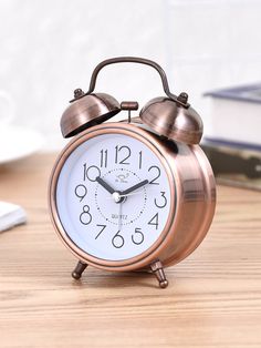 an alarm clock sitting on top of a wooden table