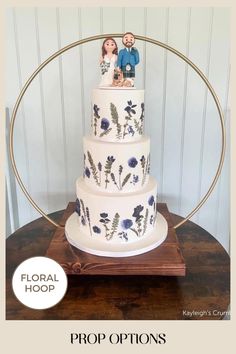 a three tiered wedding cake with figurines on top