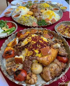 a table topped with lots of food on top of metal pans covered in sauce