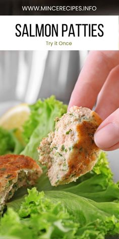 salmon patties with lettuce and lemon wedges on the side, being held up by a hand