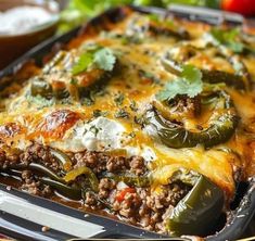 a casserole dish with meat, cheese and vegetables in it on a table