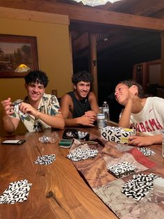 four young men sitting at a table together