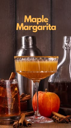 an apple margarita in a glass with cinnamons and apples around it