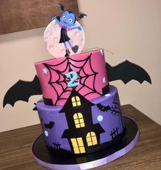 a three tiered cake decorated with an image of a batgirl on the top