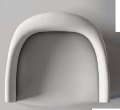 the back end of a white chair against a white wall with an oval shaped seat